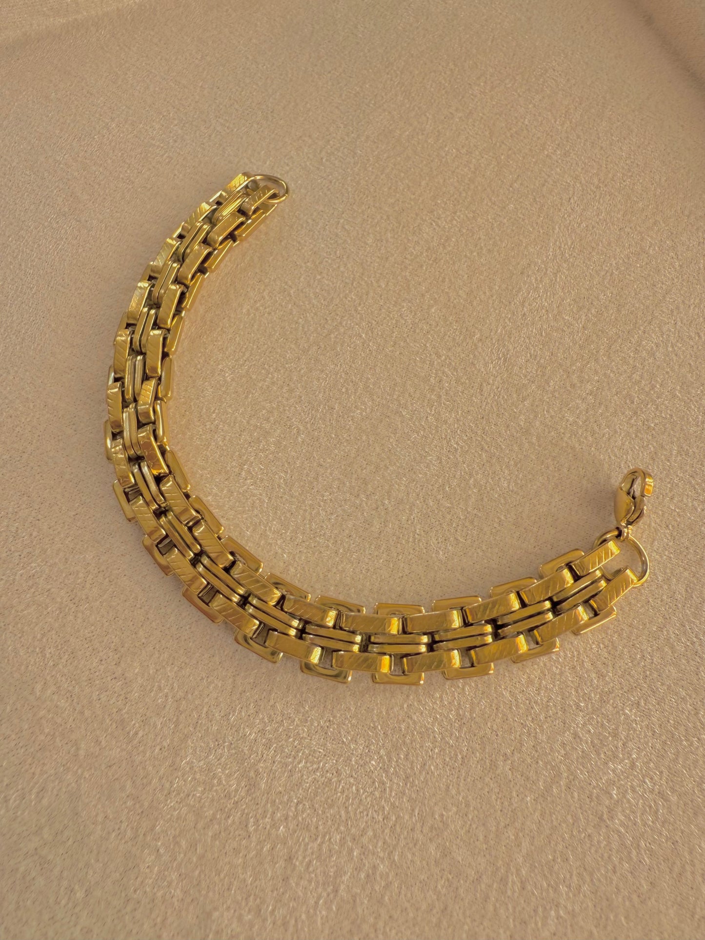 Wide gold bracelet.
