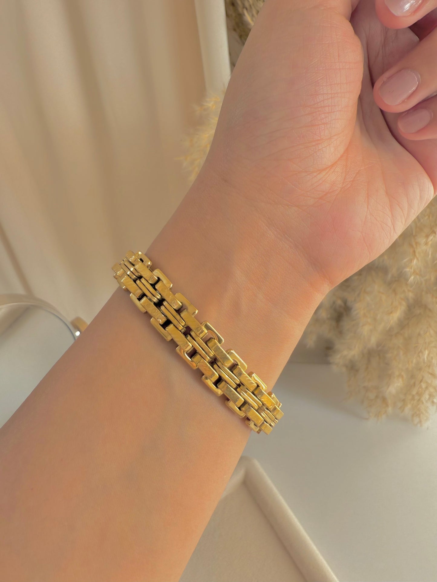 Wide gold bracelet.