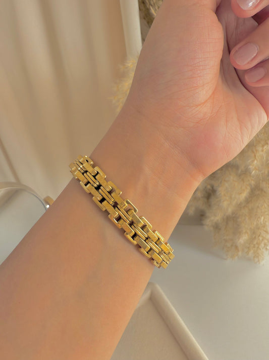 Wide gold bracelet.